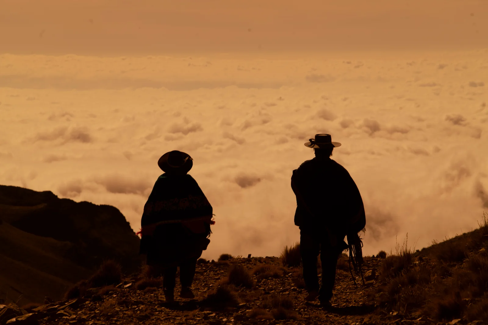 Dos productores caminando sobre un mar de nubes